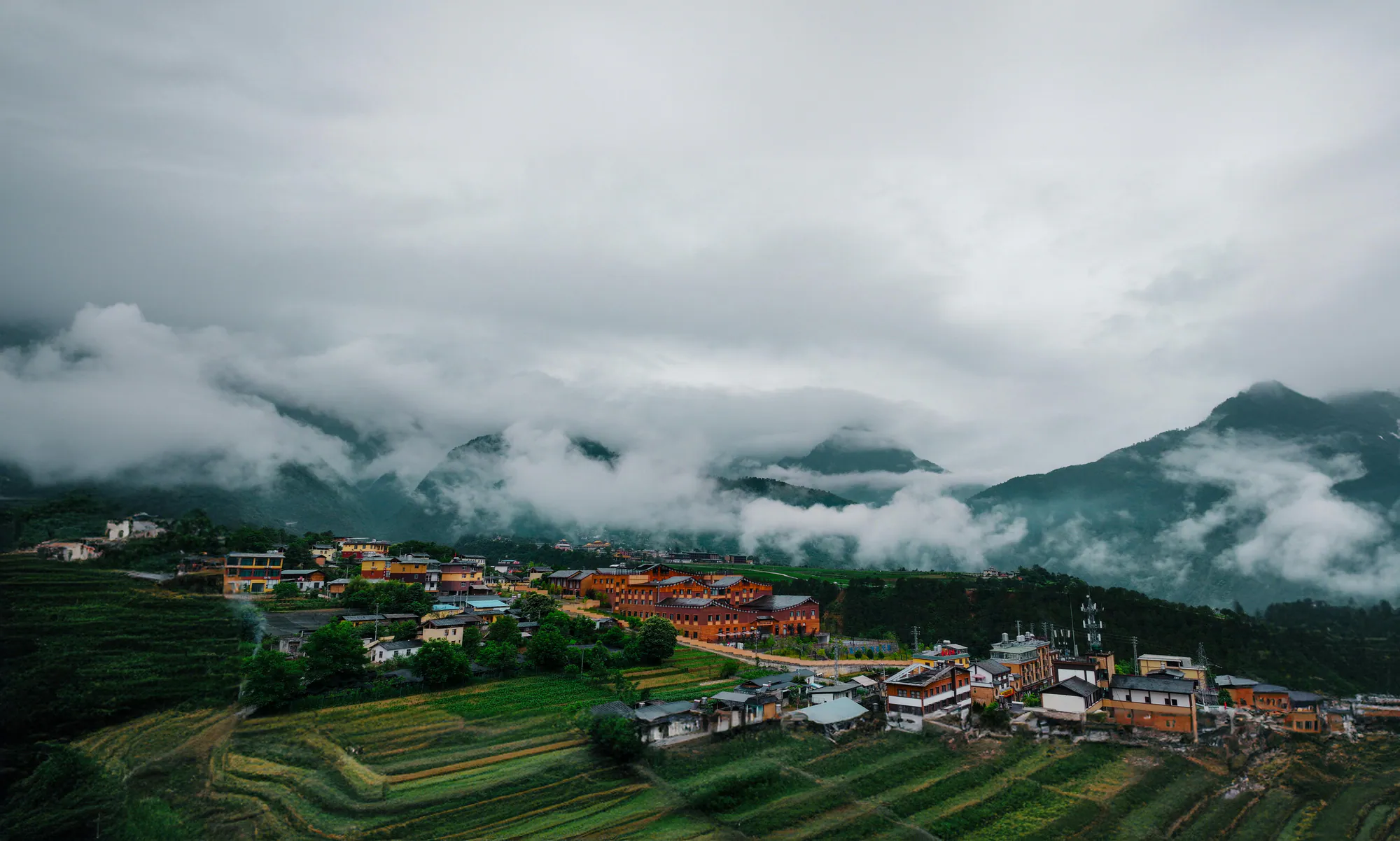 A mountain community beneath misty peaks